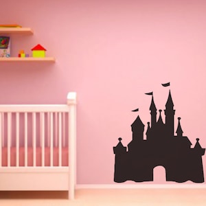 May include: Black silhouette of a fairytale castle on a pink wall. The castle has a large archway and multiple towers. The silhouette is a wall decal.