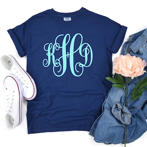 May include: A navy blue t-shirt with a light blue monogram "KFD" on the front.