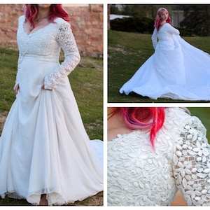 May include: A white lace wedding dress with long sleeves and a flowing skirt. The dress has a V-neckline and a fitted bodice. The model is wearing her hair in a loose updo.