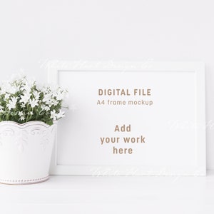 May include: White A4 frame mockup with a white pot of white flowers on a white surface. The text "DIGITAL FILE" and "A4 frame mockup" is visible in the frame. The text "Add your work here" is also visible in the frame.