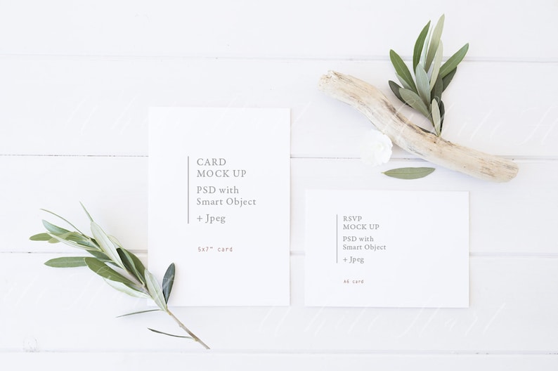 Puede incluir: Dos tarjetas blancas sobre una superficie de madera blanca con ramas verdes y un trozo de madera a la deriva. La tarjeta de la izquierda dice "CARD MOCK UP PSD with Smart Object + Jpeg 5x7" card. La tarjeta de la derecha dice "RSVP MOCK UP PSD with Smart Object + Jpeg 4x6" card.