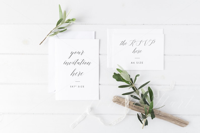 May include: Two white cards on a white wooden background with green sprigs. The larger card says "your invitation here 5x7" size. The smaller card says "the RSVP here A6 size".