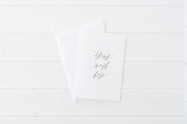 Puede incluir: Una tarjeta blanca con el texto "Your work here" escrito en caligraf&iacute;a negra sobre un fondo de madera blanca.