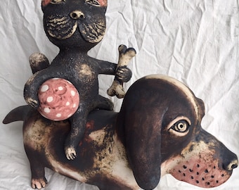 Ceramic Cat riding a Ceramic Dog with a Ball and a Bone