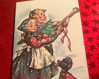 May include: Vintage Christmas card featuring two children carrying a guitar and a basket with a Christmas tree and apples. A black poodle wearing a red sweater stands in the snow. The card has a snowy background and a red ribbon.