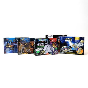 Puede incluir: Cinco cajas sin abrir de juguetes de Star Wars. Las cajas son de diferentes tamaños y presentan diferentes personajes y escenas del universo de Star Wars. Las cajas están en buen estado y no se han abierto.