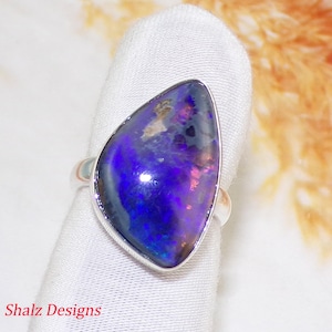 Peut inclure: Une bague en argent avec une grande pierre d'opale triangulaire, violette et noire.