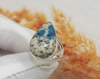 May include: A silver ring with a teardrop-shaped blue and white stone. The stone has a mottled pattern of blue and white.