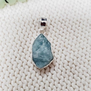 Op de afbeelding: Een zilveren hanger met een ruwe aquamarijn edelsteen. De aquamarijn is lichtblauw en heeft een natuurlijke, ruwe textuur. De hanger is perfect om elke outfit een vleugje natuur te geven.