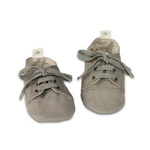 May include: A pair of small, gray canvas shoes with gray laces. The shoes have a classic sneaker design, with a rounded toe and a small tag on the tongue. The shoes are likely for a baby or toddler.