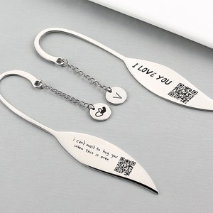 May include: Two silver bookmark pendants with a chain and charms. The top bookmark has the text "I LOVE YOU" and a QR code. The bottom bookmark has the text "I can't wait to hug you when this is over." and a QR code.