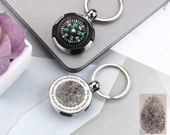 May include: A silver keychain with a compass and a round tag engraved with a fingerprint and the text "I wish I could give you the world, but you deserve so much more than that."