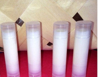 May include: Four clear tubes of lip balm, each filled with a white, opaque substance. The tubes are arranged in a row on a red surface.