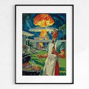 May include: A framed art print depicting a person in a striped shirt and white apron standing in a backyard, holding a spatula and a bottle, while a large mushroom cloud explosion occurs in the background behind a modern house and a charcoal grill.