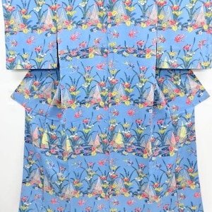 May include: A blue kimono with a floral pattern. The pattern features pink, yellow, and white flowers on a light blue background.