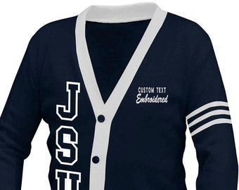 Op de afbeelding: Marineblau vest met witte randen en de letters "JSU" in witte blokletters. De tekst "CUSTOM TEXT Embroidered" staat boven de zak. De mouwen hebben witte strepen.