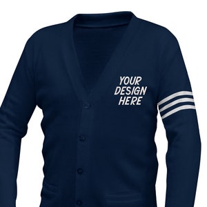 May include: Navy blue cardigan sweater with a V-neck, button closure, and two front pockets. The left sleeve has three white stripes. The text "YOUR DESIGN HERE" is printed on the left chest.