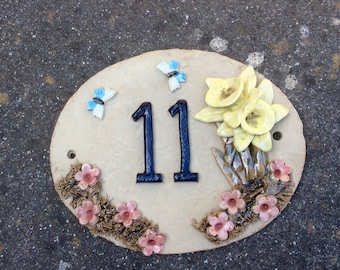 House numbers, address plaque, daffodil door number.