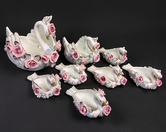 JUEGO DE CUENCOS DE CISNES… 8 cisnes de porcelana… Cuencos/platos para objetos pequeños… Cisne central grande y platos más pequeños con forma de cisne… Rosas y pétalos rosas aplicados… Detalles dorados… Década de 1940