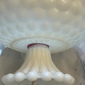 May include: White milk glass lamp base with a textured bubble design. The base has a fluted pedestal and a scalloped bottom edge.