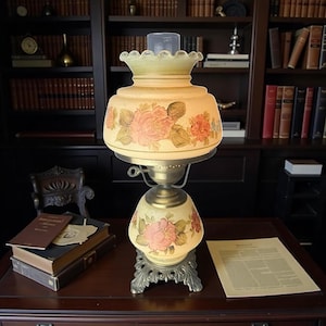 Puede incluir: Una l&aacute;mpara de mesa de estilo vintage con un dise&ntilde;o floral. La l&aacute;mpara presenta una pantalla de vidrio color crema adornada con rosas rosas y hojas verdes. La base es de metal decorativo con un dise&ntilde;o ornamentado. La l&aacute;mpara mide unos 46 cm de alto.
