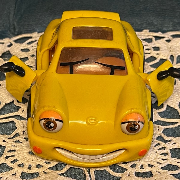 1998 TINA TURBO Plastic Yellow Toy Car…Smiling car. Doors and Trunk Open…The Chevron Cars…No. 12. China #52