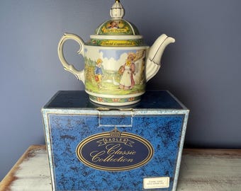 May include: A white porcelain teapot with a blue and gold design featuring a scene from the book David Copperfield by Charles Dickens. The teapot is in a blue box with the words "Sadler Classic Collection" printed on it.