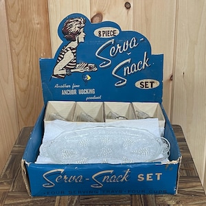 May include: A blue and white cardboard box with the text "Serva-Snack SET" and "Another fine ANCHOR HOCKING product". The box contains an 8-piece glass serving set with four serving trays and four cups.