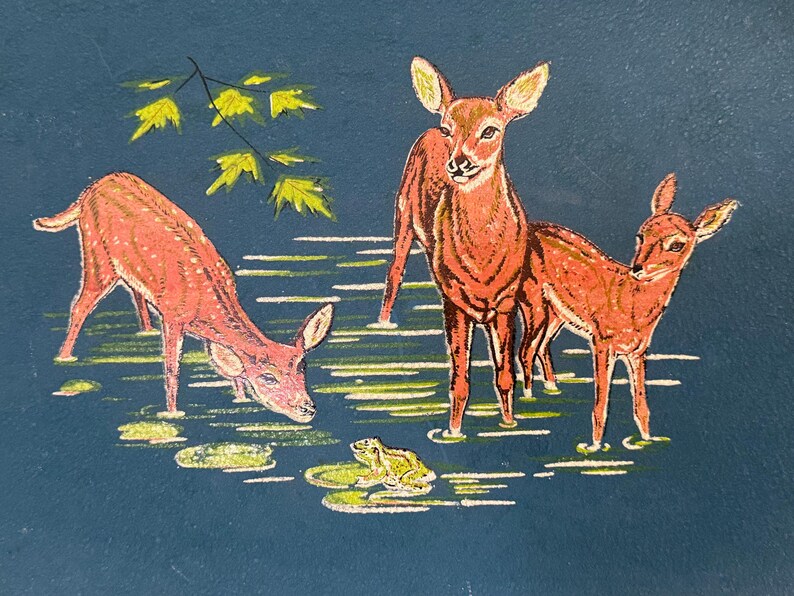 May include: A painting of three deer in a pond with a frog and lily pads. The deer are reddish-brown with white accents, and the water is a dark blue. Yellow leaves are in the upper left.