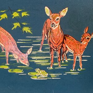 May include: A vintage illustration depicts three deer standing in water with lily pads and a frog. The deer are various shades of brown and pink, set against a dark blue background. Green leaves are in the upper left corner.