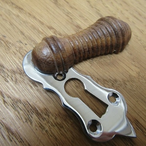 May include: A polished chrome door knob with a wooden handle. The handle is a dark brown color and has a ribbed texture. The knob is designed for a single door.