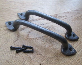 May include: Two dark grey, cast iron handles with a curved design, each with a triangular base and two screw holes. Includes a set of black screws. Suitable for cabinet or drawer hardware.