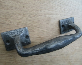 May include: A black metal drawer pull with a curved handle and square mounting plates.