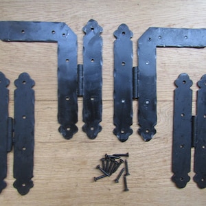 Puede incluir: Conjunto de seis bisagras de metal negro con detalles decorativos. Las bisagras están diseñadas para su uso en puertas o portones. El conjunto incluye tornillos para la instalación.