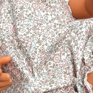 May include: White fabric with a small floral pattern in shades of pink, blue, and brown.