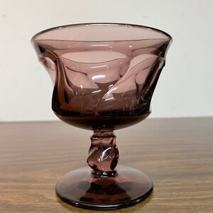 May include: A purple glass goblet with a twisted stem and a wide, flared bowl.