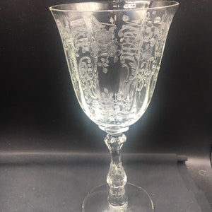 May include: A clear glass wine goblet with an etched floral design.