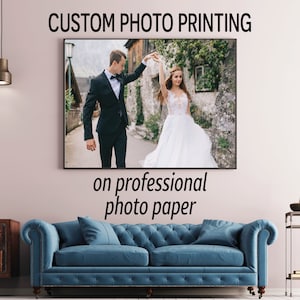 May include: A custom photo print of a couple dancing in a street setting. The print is on professional photo paper and is displayed on a blue sofa in a living room setting.