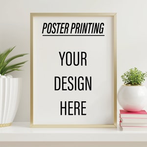 May include: A gold framed poster mockup with the text "POSTER PRINTING YOUR DESIGN HERE" on a white background. The poster is on a white shelf with potted plants and books.