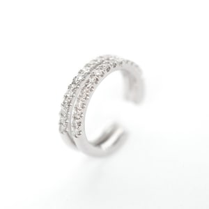May include: A silver ear cuff with a double row of clear cubic zirconia stones.