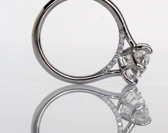 May include: A silver engagement ring with a large, round, clear diamond center stone and smaller diamonds set in the band.