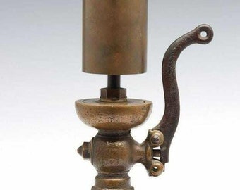 An ornate late 19th century single note brass steam whistle w cast iron base