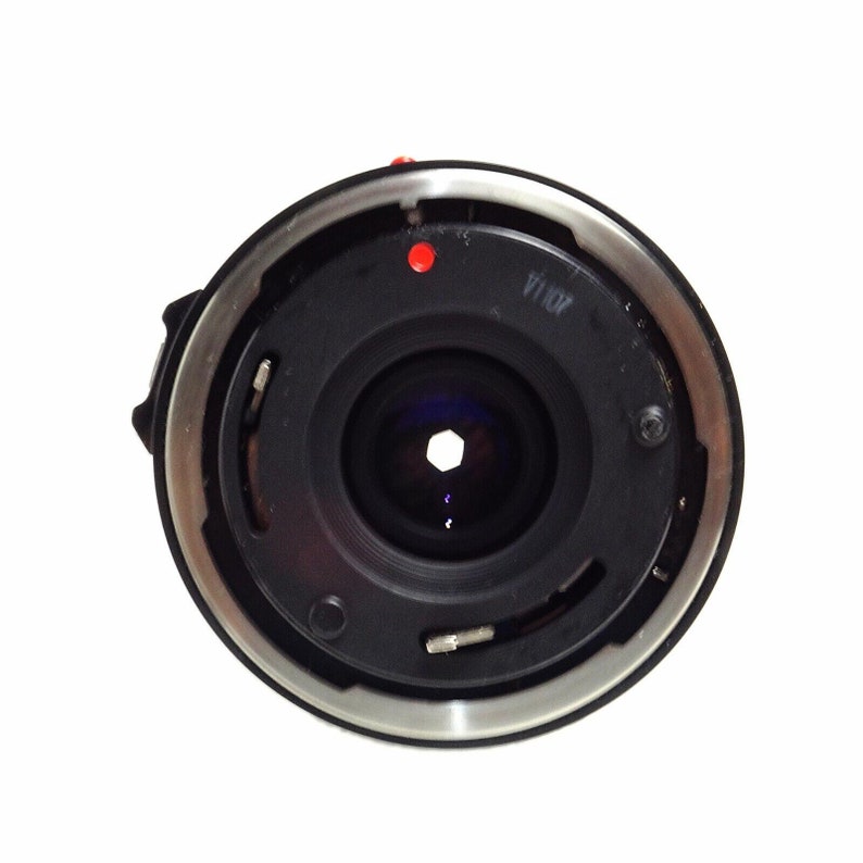 May include: A black camera lens with a silver ring around the edge. The lens has a red dot on the top and the text "f/1.8" printed on the side.