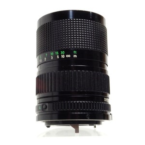 May include: A black Canon FD 35mm f/2.8 lens with a green depth of field scale marked in feet and meters.