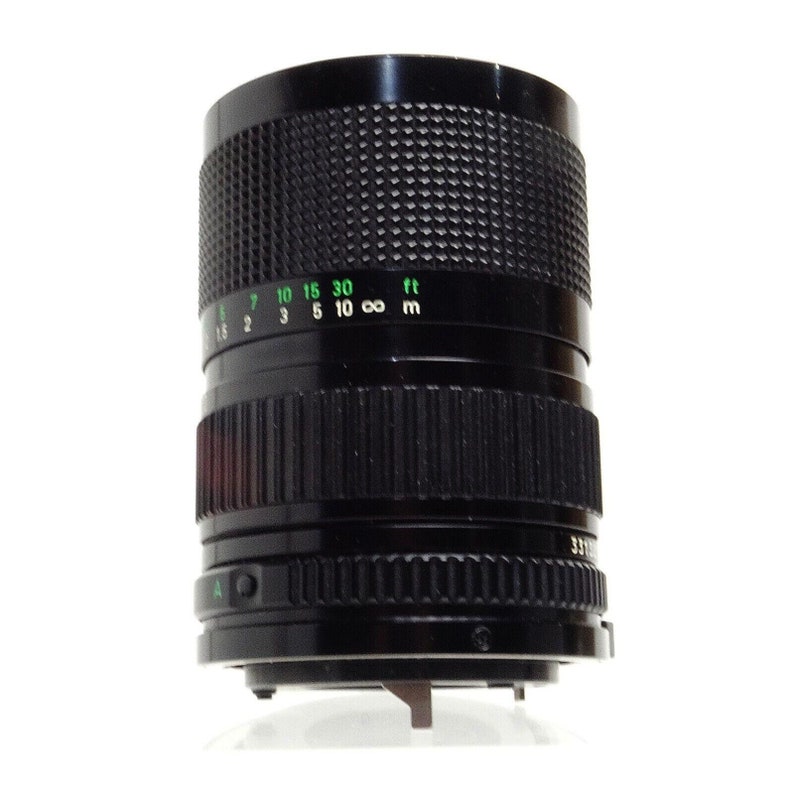 May include: A black Canon FD 35mm f/2.8 lens with a green depth of field scale marked in feet and meters.