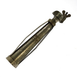 May include: A silver-colored metal object with a long, narrow, cylindrical body and a small, round head. The object has a textured surface and a hinged clamp on the head.
