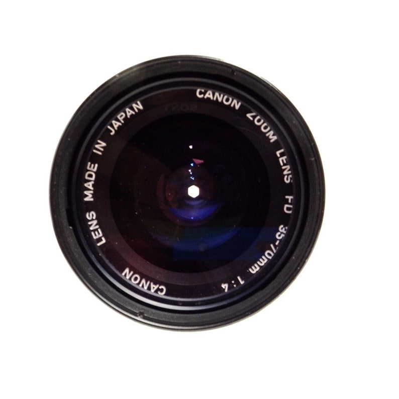 May include: A black Canon FD 35-70mm 1:4 zoom lens, made in Japan. The lens is designed for 35mm film cameras.