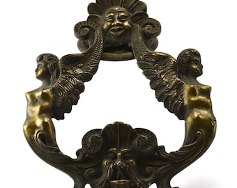 Antique massive brass door knocker with winged figures angles in an Asian motif