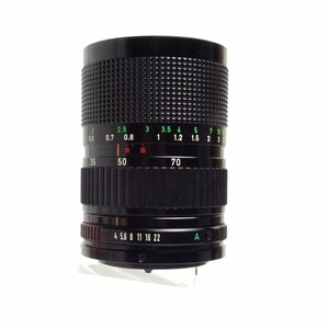 May include: A black camera lens with a green and white aperture ring. The ring has markings for f-stops from 0.6 to 10 and focal lengths from 35 to 70. The lens also has a black ring with markings for aperture settings from 4 to 22.