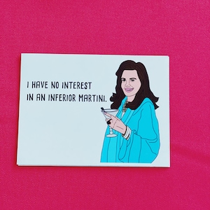 May include: A white card with black text that reads "I have no interest in an inferior martini." A cartoon illustration of a woman with long brown hair holding a martini glass is on the right side of the card.